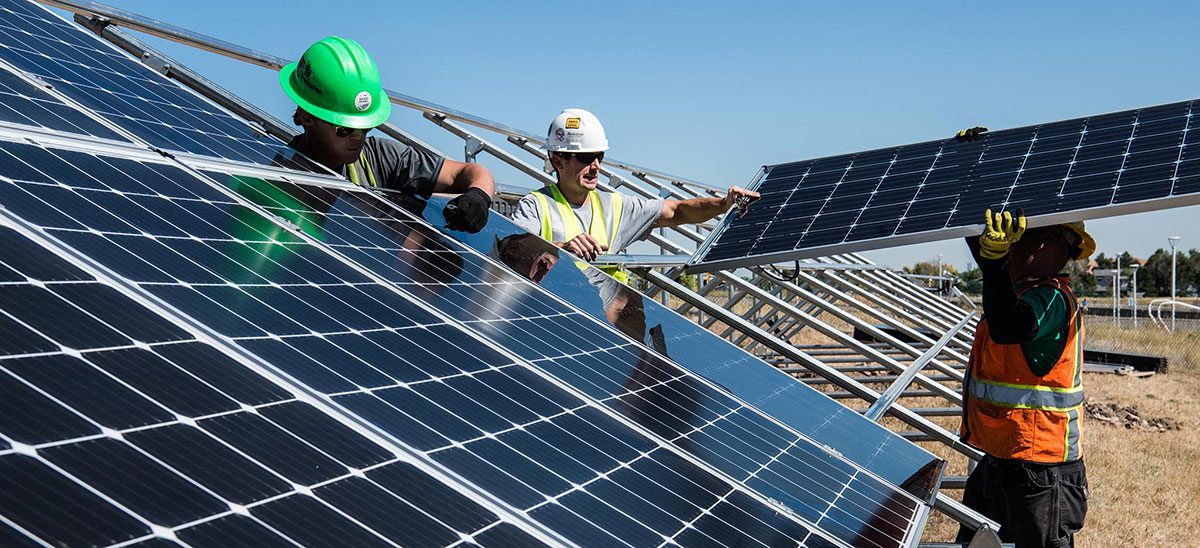 Monteure installieren Solarmodule auf einer Unterkonstruktion