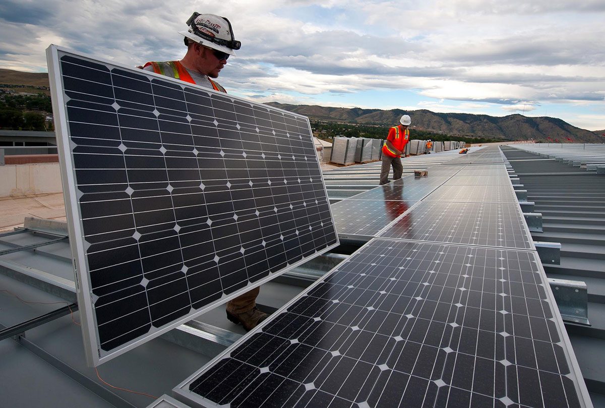 Monteur richtet ein Solarmodul auf einem Dach aus